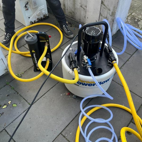 Een specialist controleert de druk tijdens een preventieve spoelbeurt van de vloerverwarming.